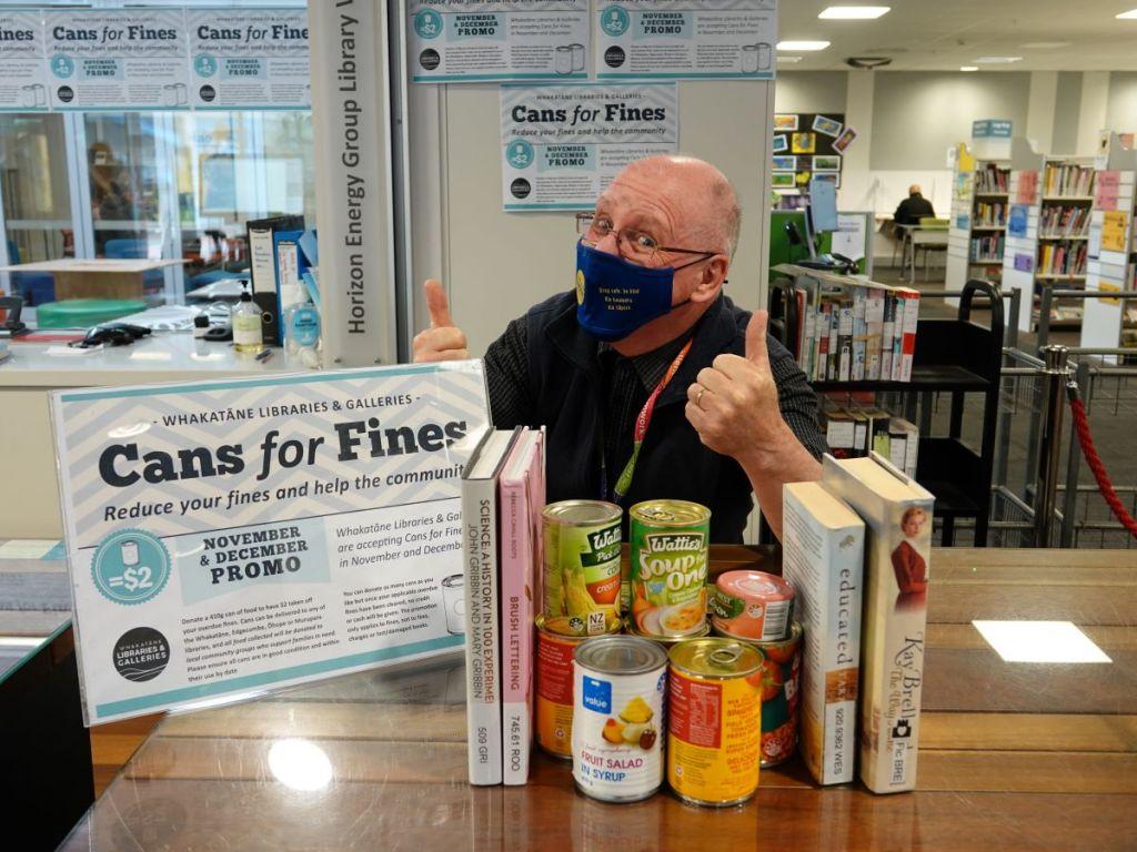 John with cans and books
